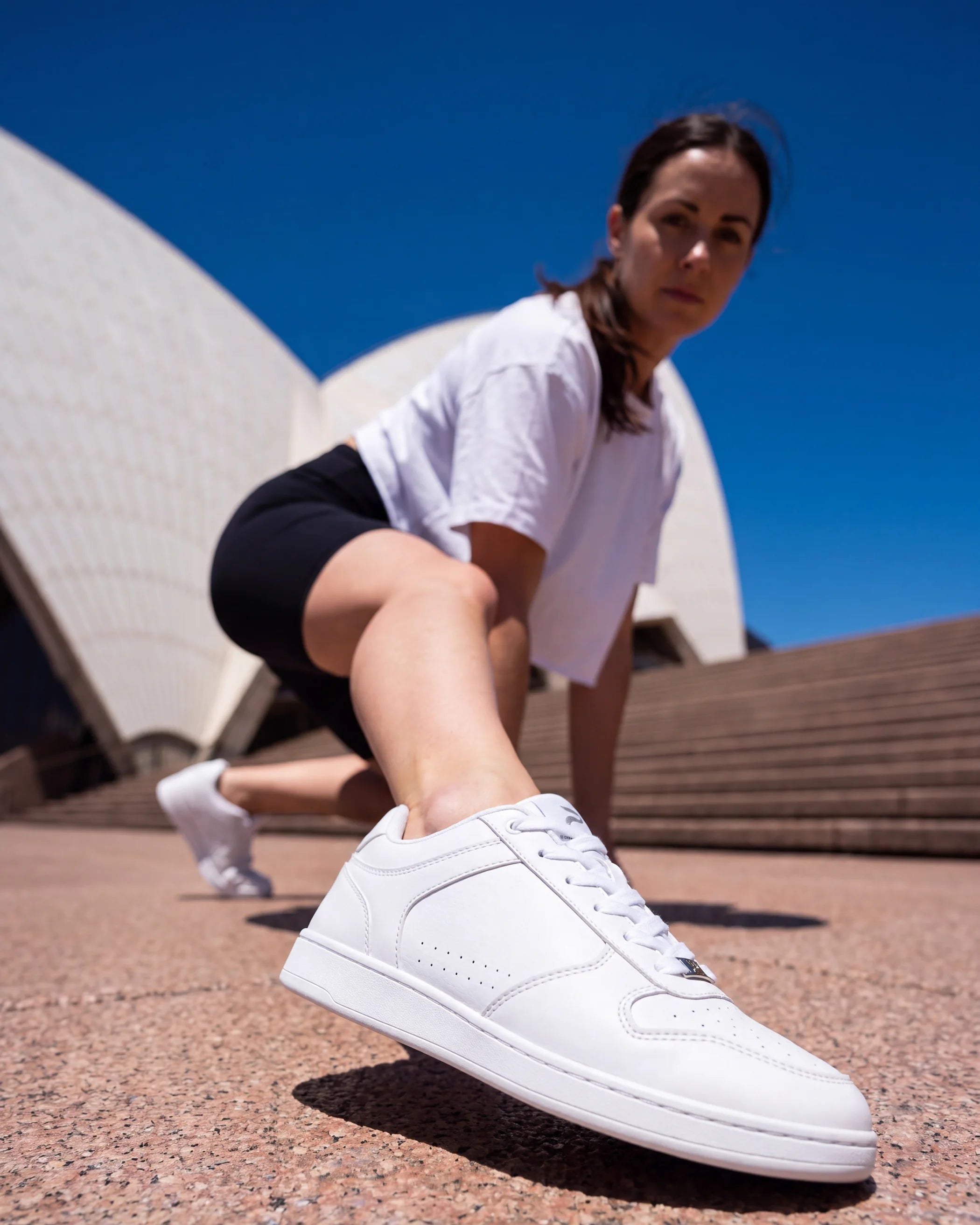 Dancer lunging in front of the Sydney Opera House in Flow 2 White dance sneakers